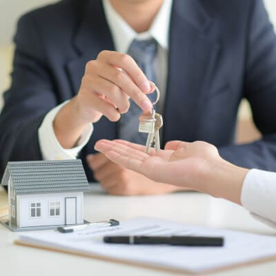 Agent giving keys to new home owner